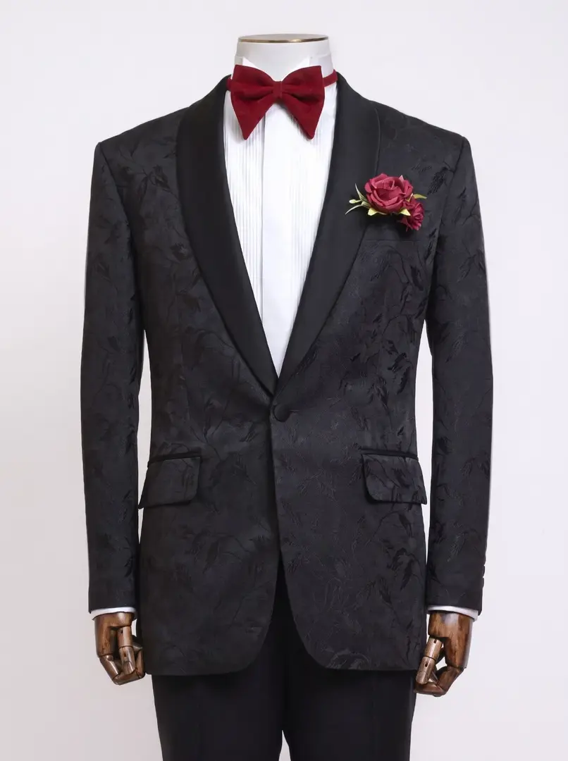 Black patterned groom's suit with a red bow tie, made by Laxmi Tailors